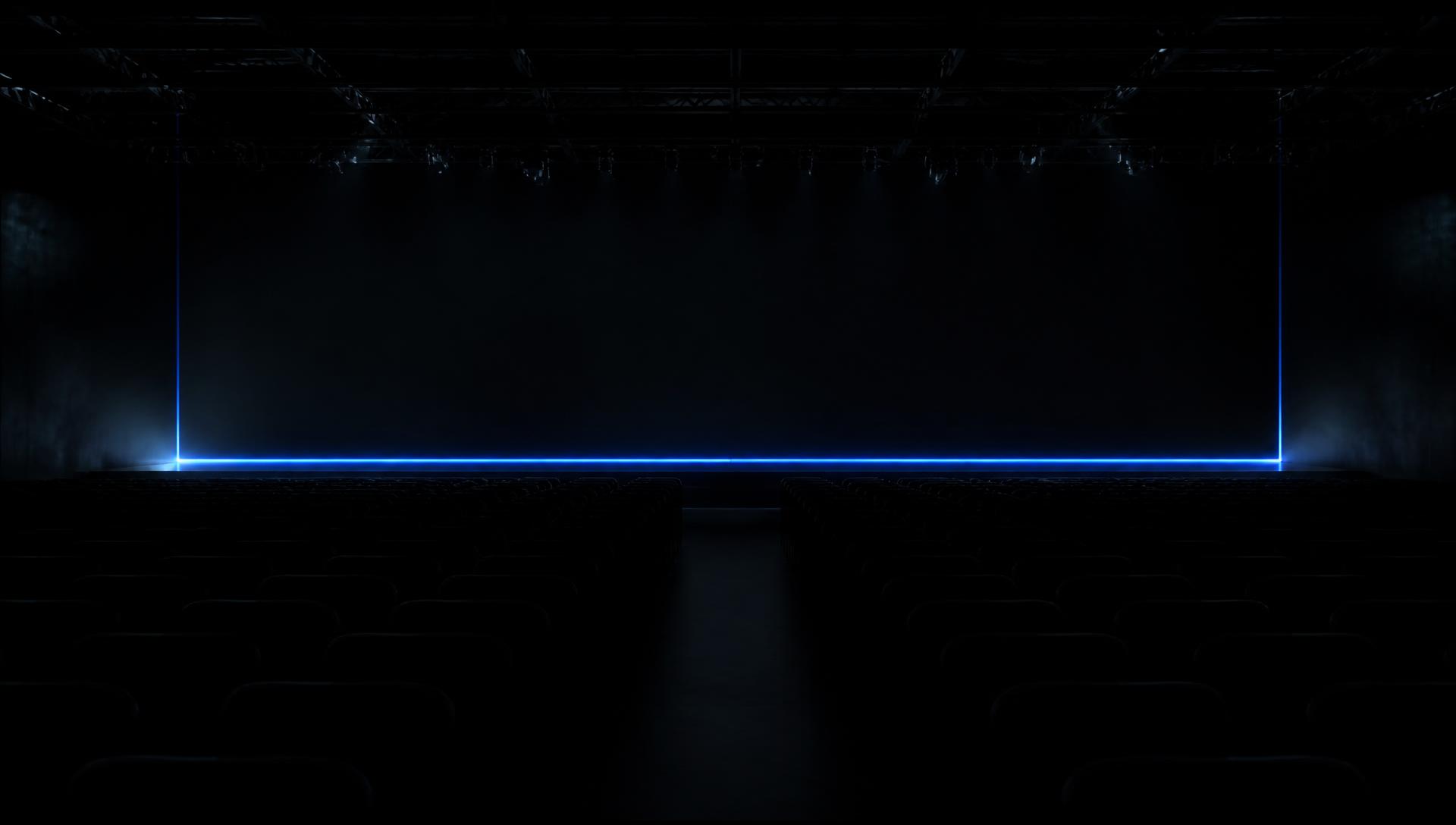 Dark keynote stage lit by a single blue light strip